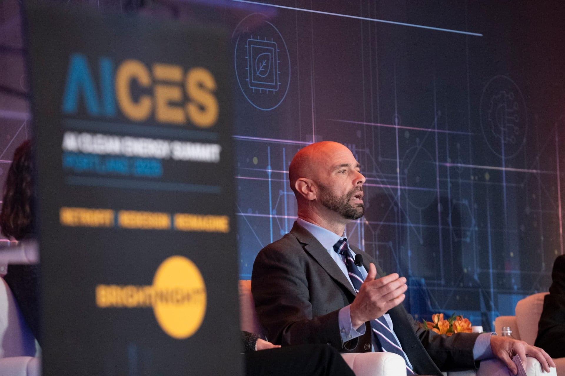 Keynote speaker on stage with dramatic lighting captured by MAGNIFY Photo videography team